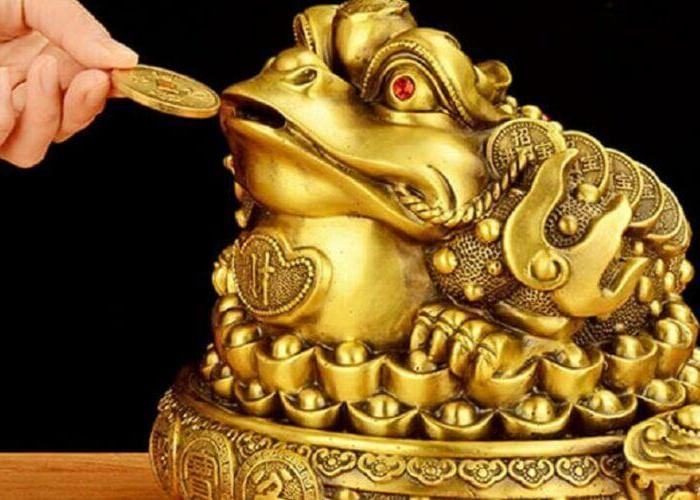 Vật phẩm phong thuỷ Thiềm Thừ chỉ có 3 chân và ngồi trên tấm thảm đầy tiền vàng, châu báu