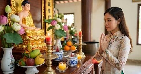 Người phụ nữ thành tâm cầu nguyện tại bàn thờ